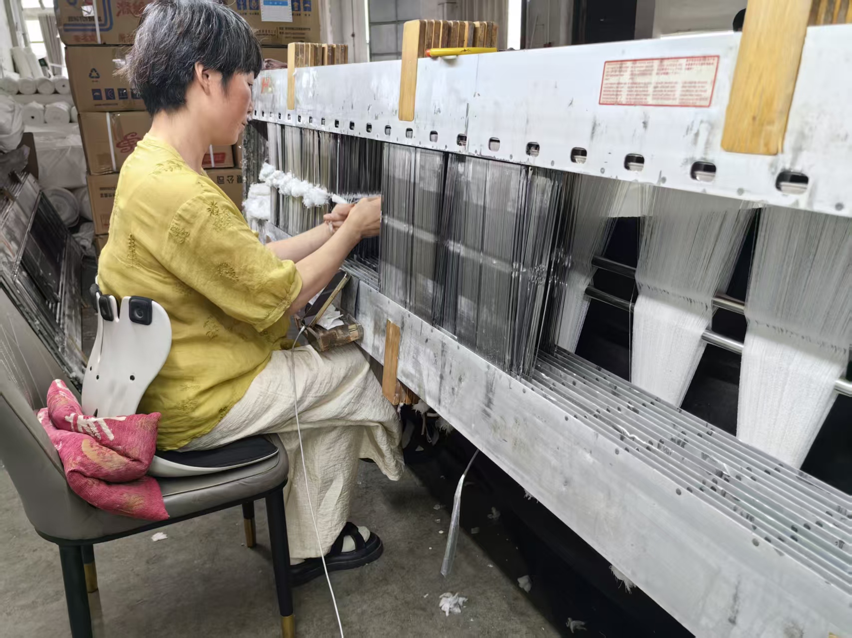 Rolls of grey fabric coming off the loom
