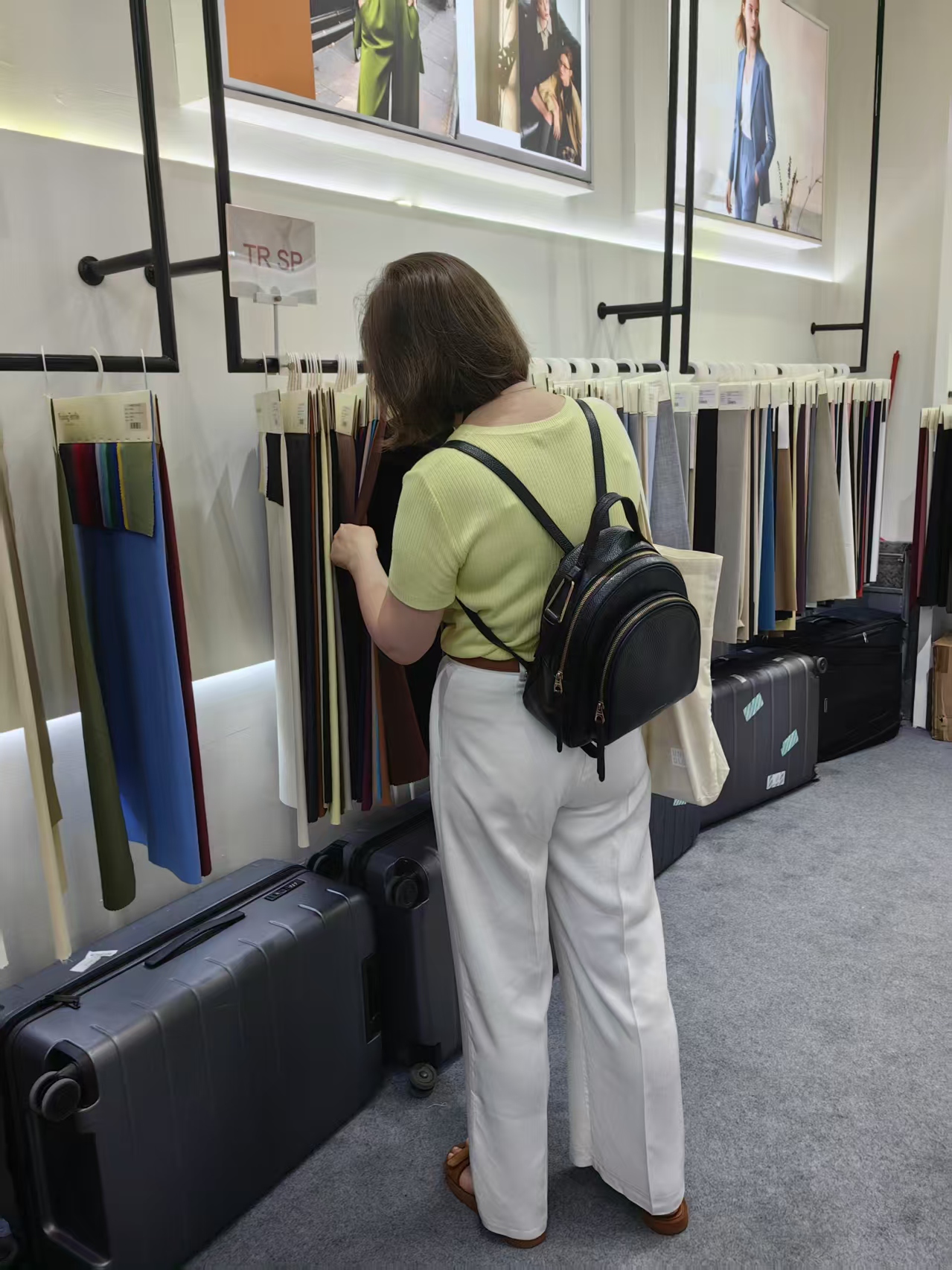 Two visitors speaking with staff at the fabric rack