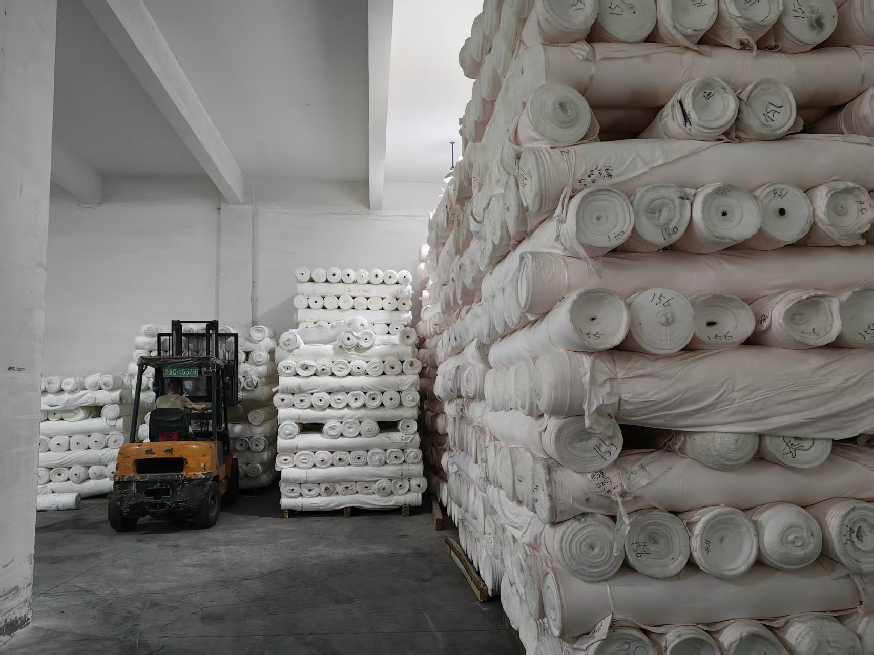 Grey fabric bolts stacked in the Fuxing Textile grey fabric warehouse