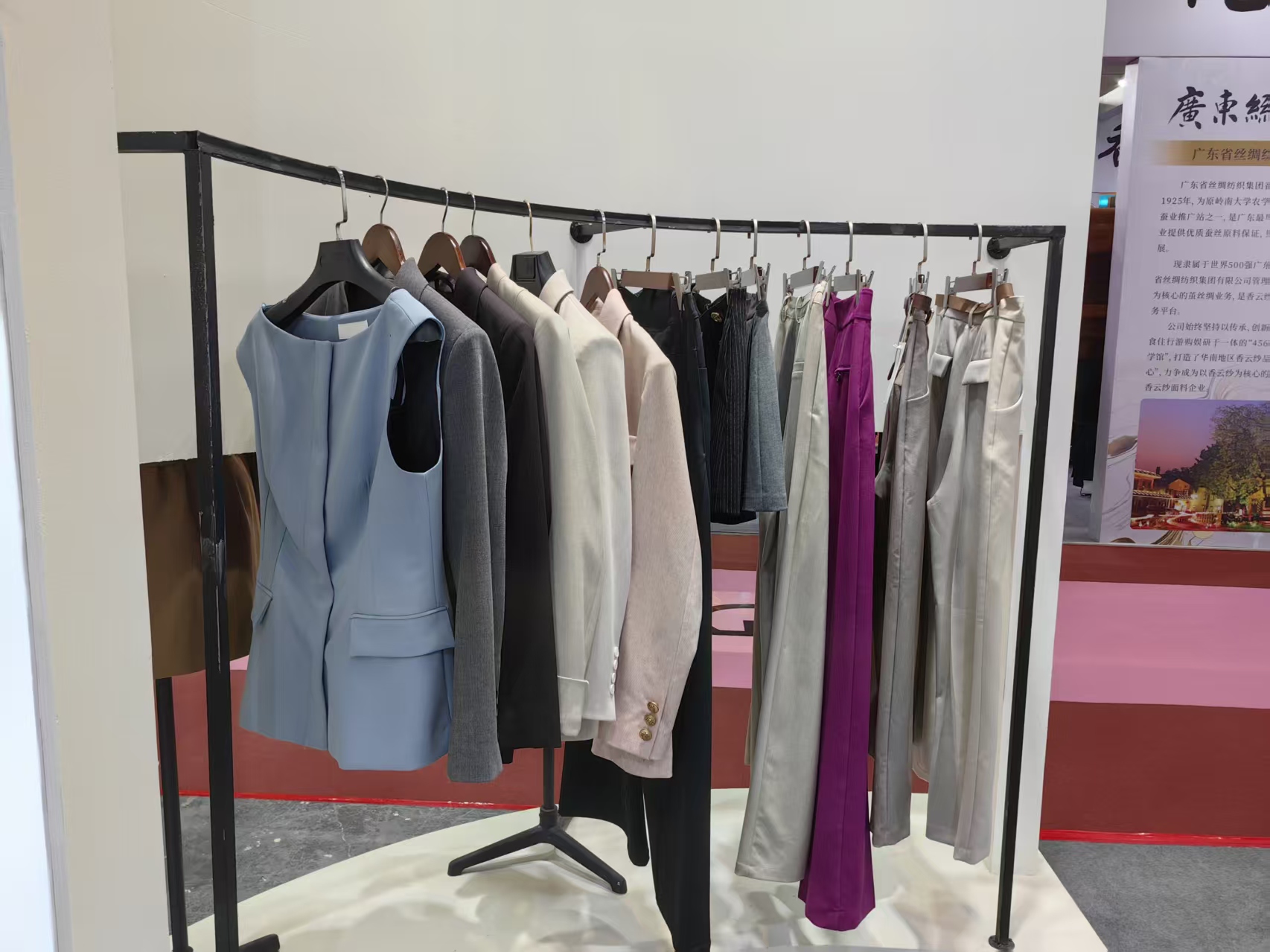 Mannequin dressed in a finished look next to fabric rack