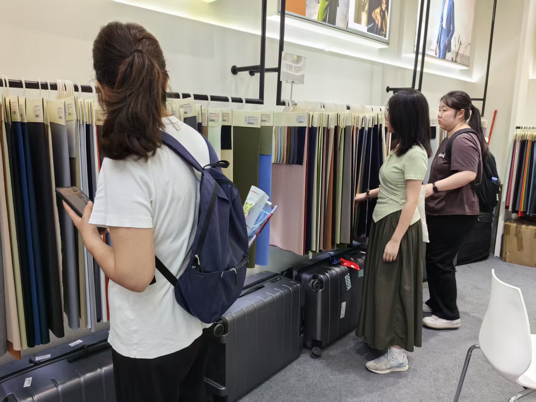 Visitor checking wool fabric rack at the Fuxing Textile booth